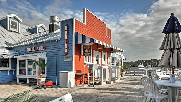 A waterfront restaurant with outdoor seating and a sign for the General Store.