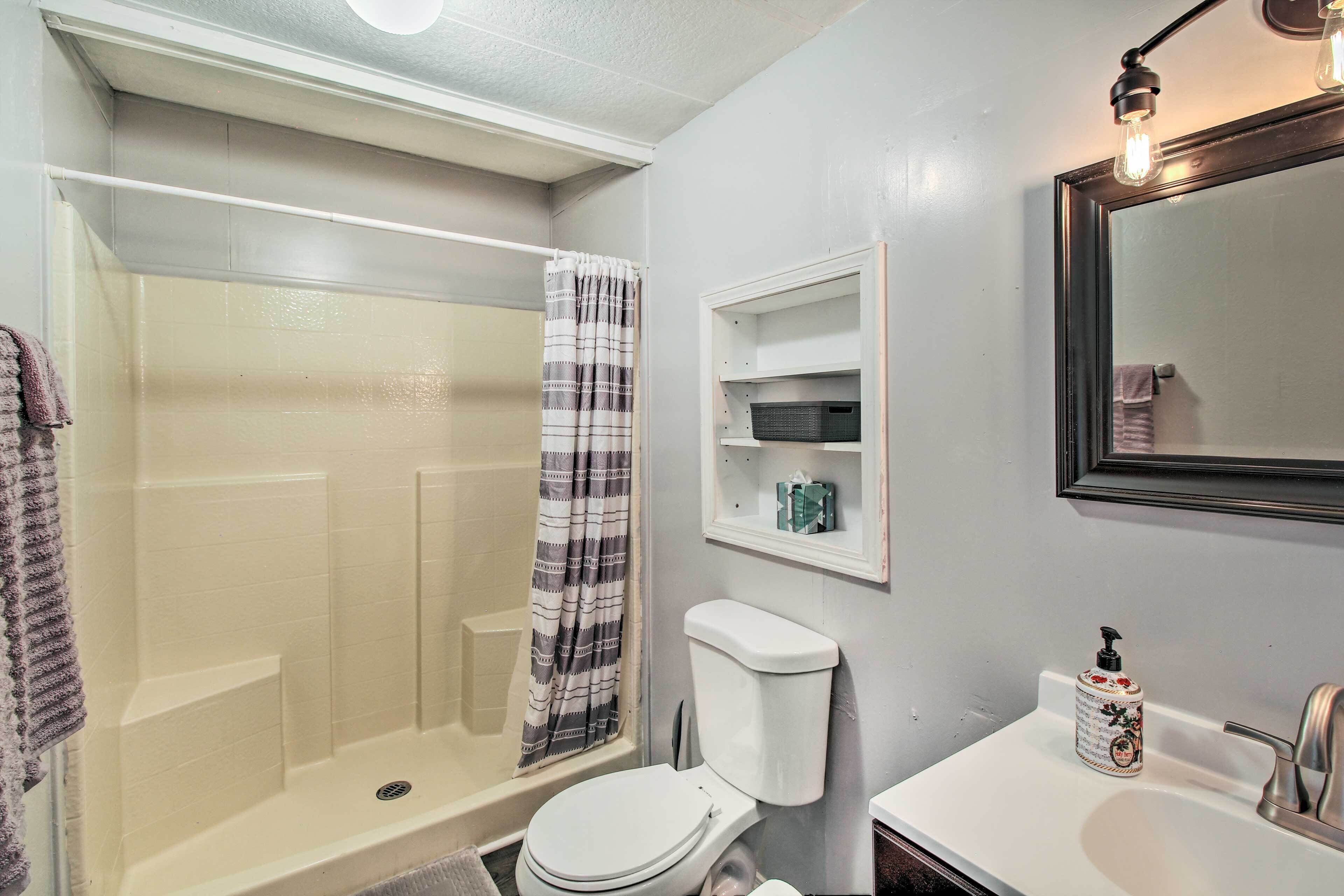 Une salle de bain équipée d’une douche, de toilettes, d’un lavabo et d’un miroir.
