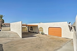 Una casa moderna con garaje, entrada para vehículos y un cielo azul despejado.