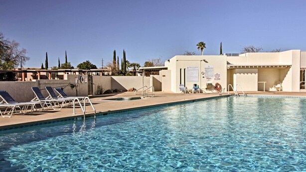 A swimming pool with clear water, sun loungers, and a covered area with a sign. - Green Valley Townhome w/ Patio & Resort Amenities (Green Valley)