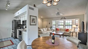 A modern kitchen with white cabinets, a black refrigerator, and a dining area with a wooden table and chairs. - 1 Mi to Golf! Family-friendly Sun City West Home (Sun City West)