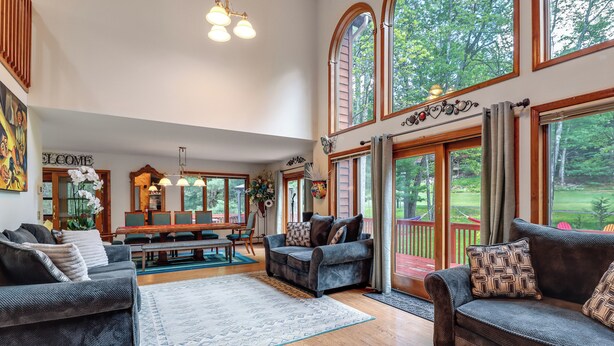 A spacious living room with a large window, a fireplace, and a dining area.