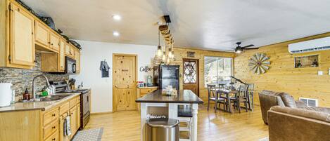 A spacious kitchen with wooden cabinets, a central island, and a dining area with a table and chairs.