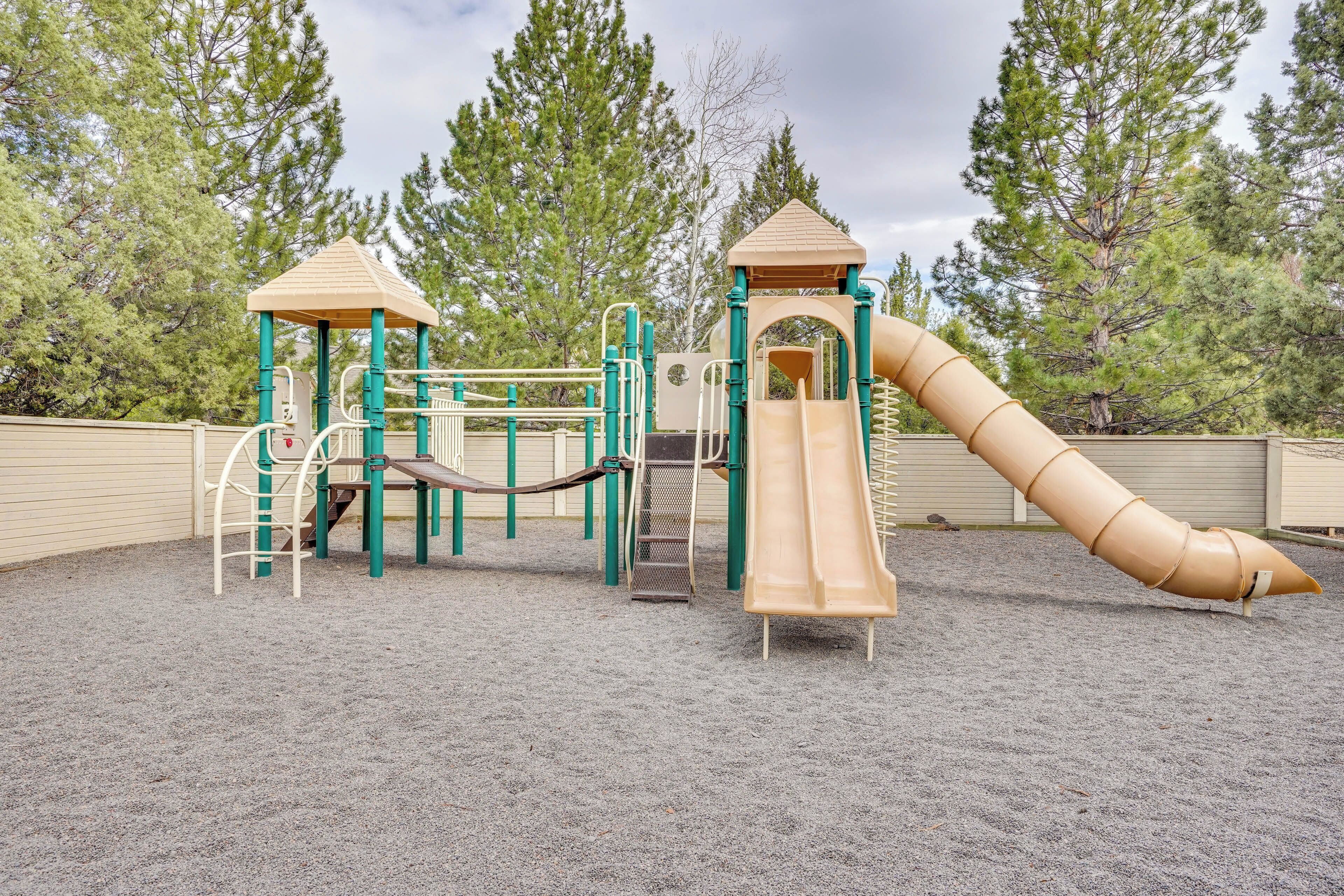 A playground with a slide, climbing structures, and a covered play area.