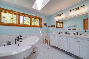 A bathroom with a freestanding bathtub, a large mirror, and a window with wooden frames. - 5 Mi to Schuss Mtn: Family Getaway w/ Game Room (Bellaire)