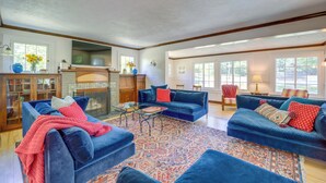 A spacious living room with a fireplace, blue sofas, and a patterned rug. - 5 Mi to Schuss Mtn: Family Getaway w/ Game Room (Bellaire)