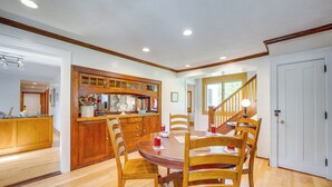 A dining area with a wooden table and chairs, a kitchen with wooden cabinets, and a staircase leading to another level. - 5 Mi to Schuss Mtn: Family Getaway w/ Game Room (Bellaire)