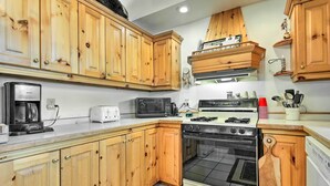 A kitchen with wooden cabinets, a microwave, a toaster, a stove, and a dishwasher. - Lakefront Phelps Cottage w/ Private Boat Dock (Eagle River)