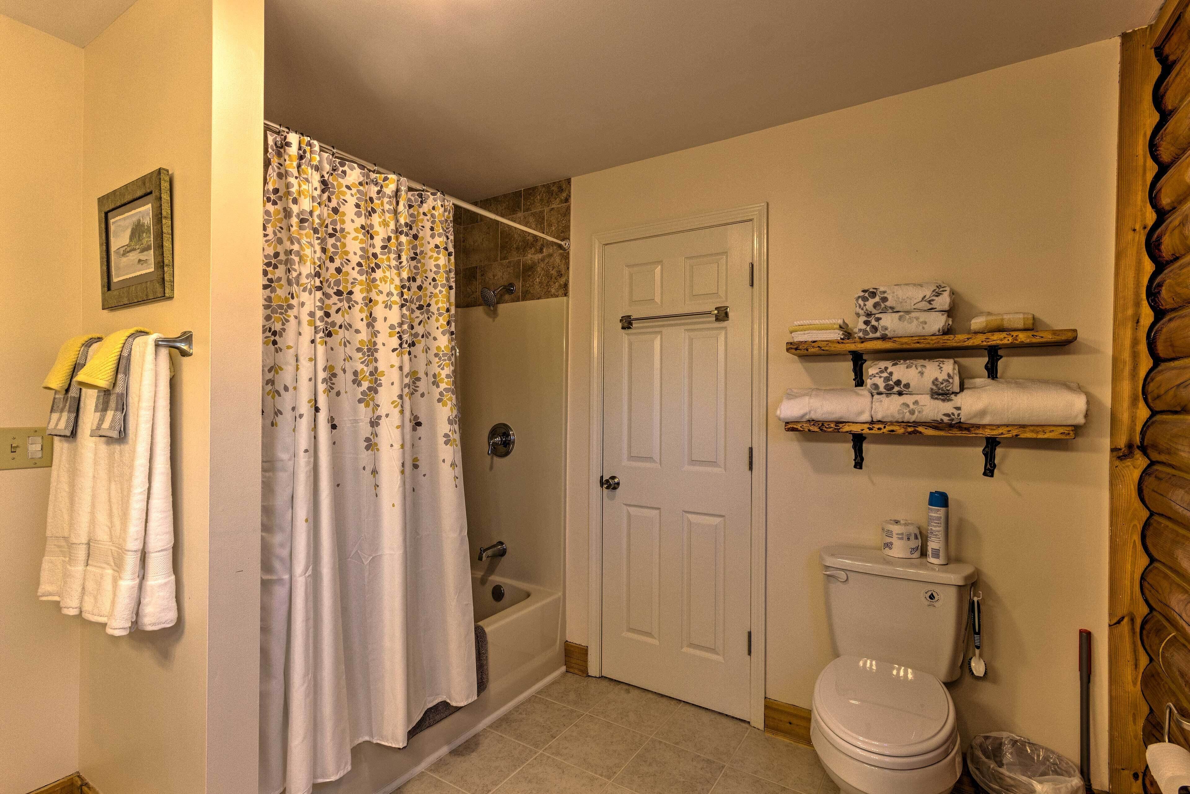 A bathroom with a shower, toilet, and towel rack.