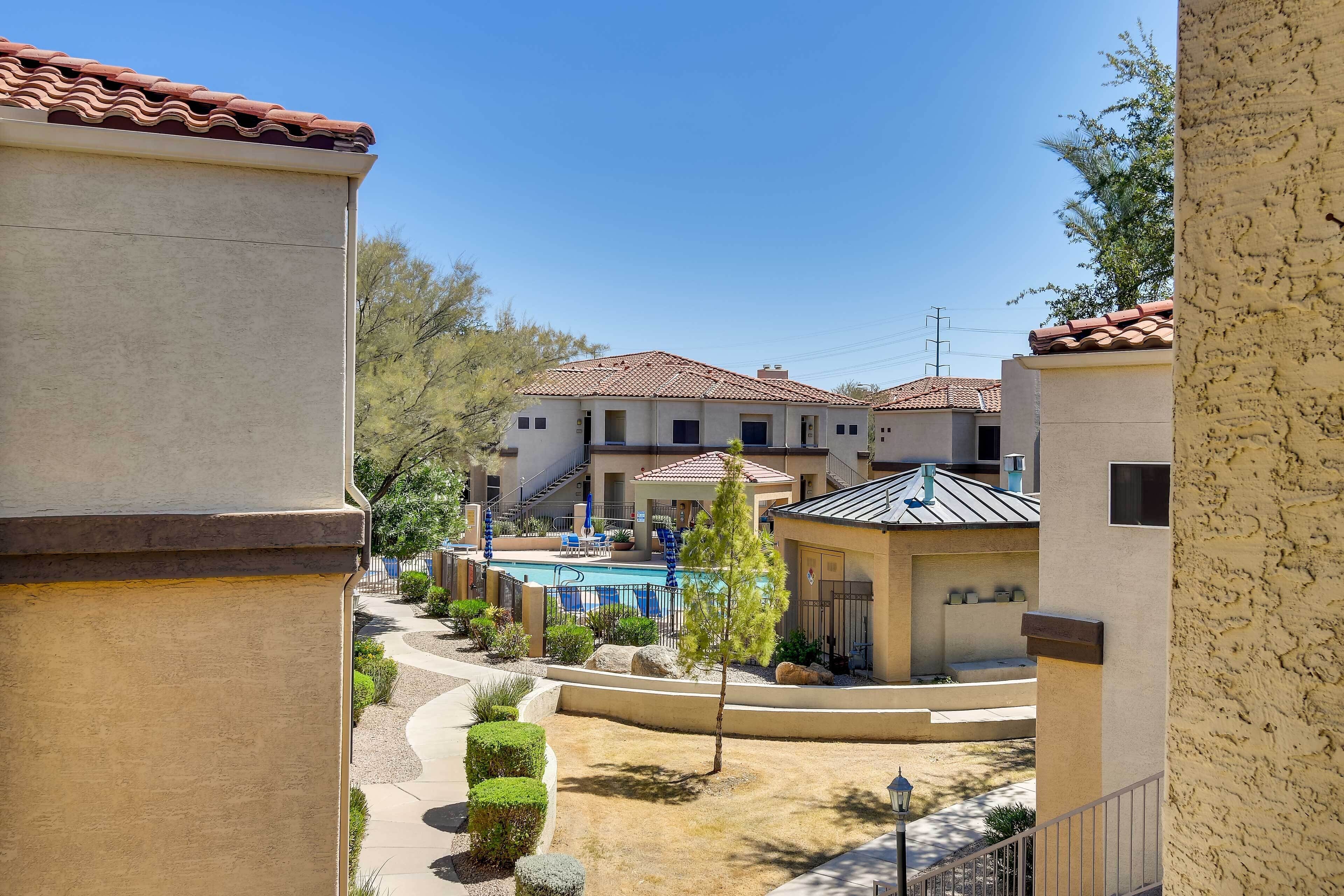 A residential area with a swimming pool, a small gazebo, and a well-maintained garden.