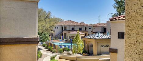 A residential area with a swimming pool, a small gazebo, and a well-maintained garden.