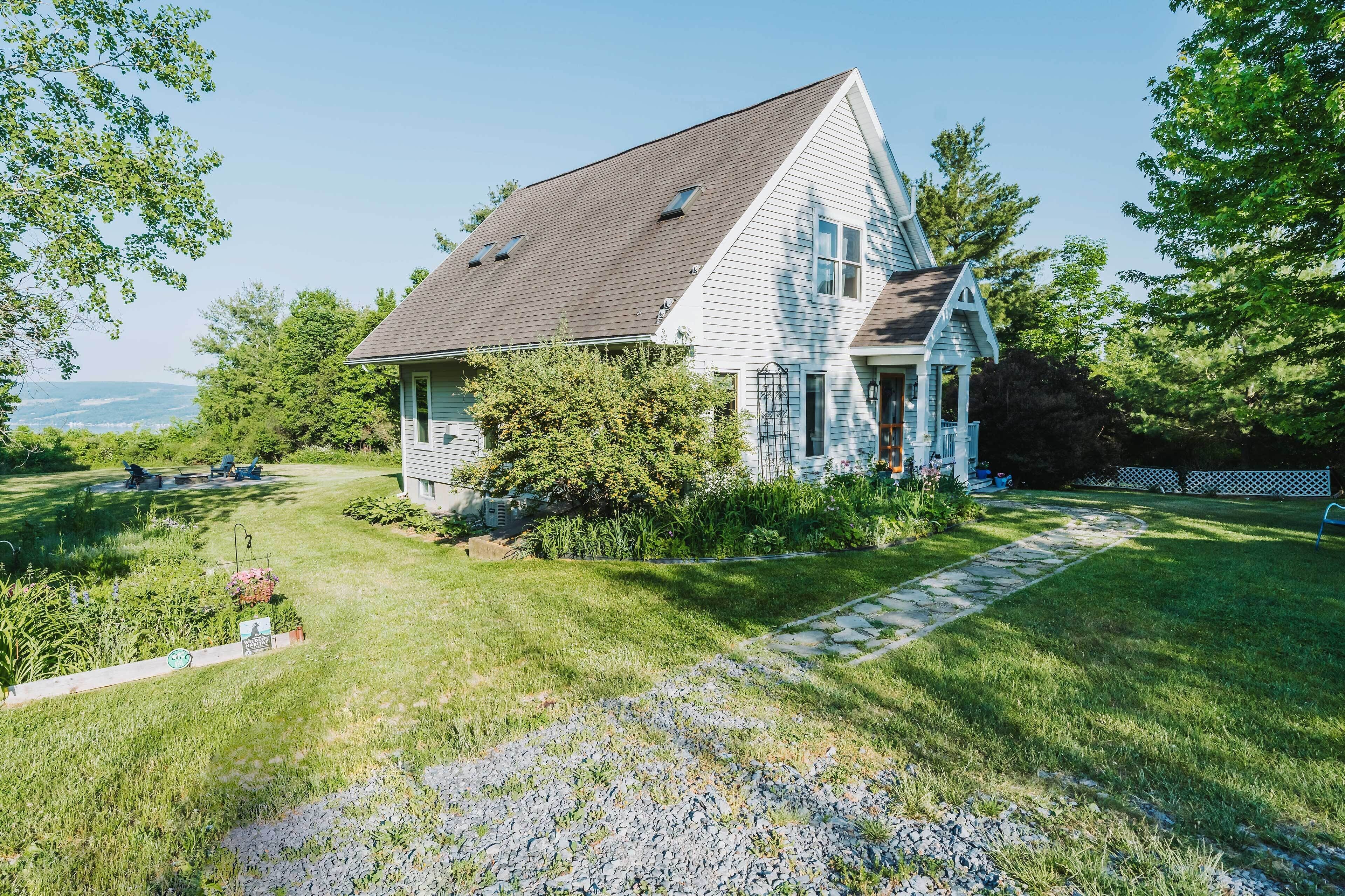 A single-story house with a gabled roof, a front porch, and a stone pathway leading to the entrance.