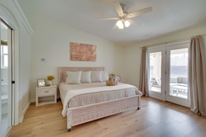 A bedroom with a bed, nightstand, and a ceiling fan.