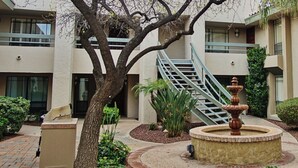 A courtyard with a fountain, a tree, and a staircase leading to an upper level. - Walk to Fashion Park! Phoenix Abode w/ Pool Access (Phoenix)