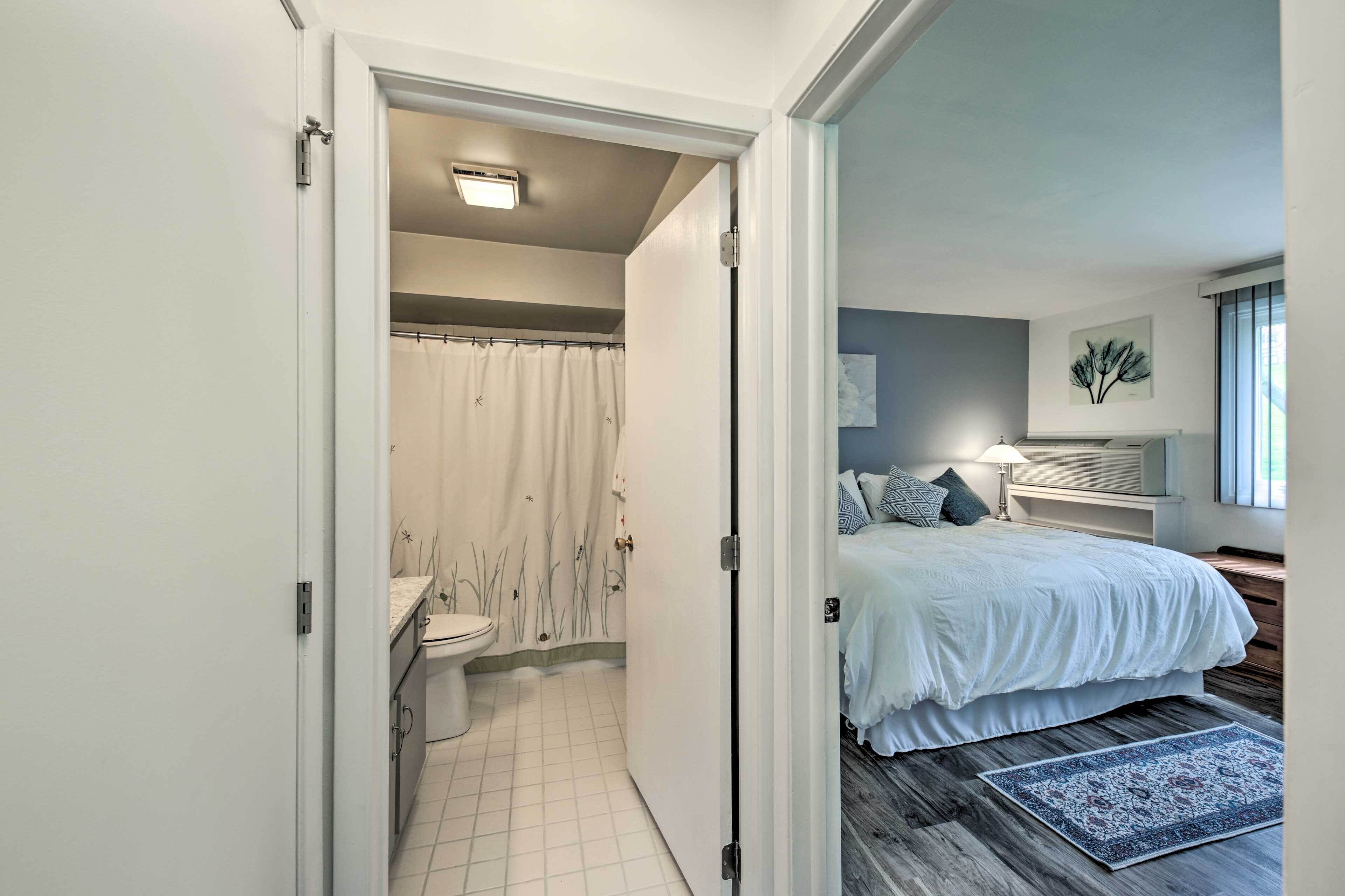 A bedroom with a bed, bedside table, and a window with a view.