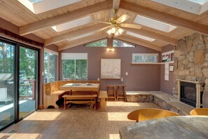 A spacious room with a high ceiling, wooden beams, a stone fireplace, and a dining area with benches. - Game Room! Group Lake House, 25 Mi to Yosemite (Groveland)