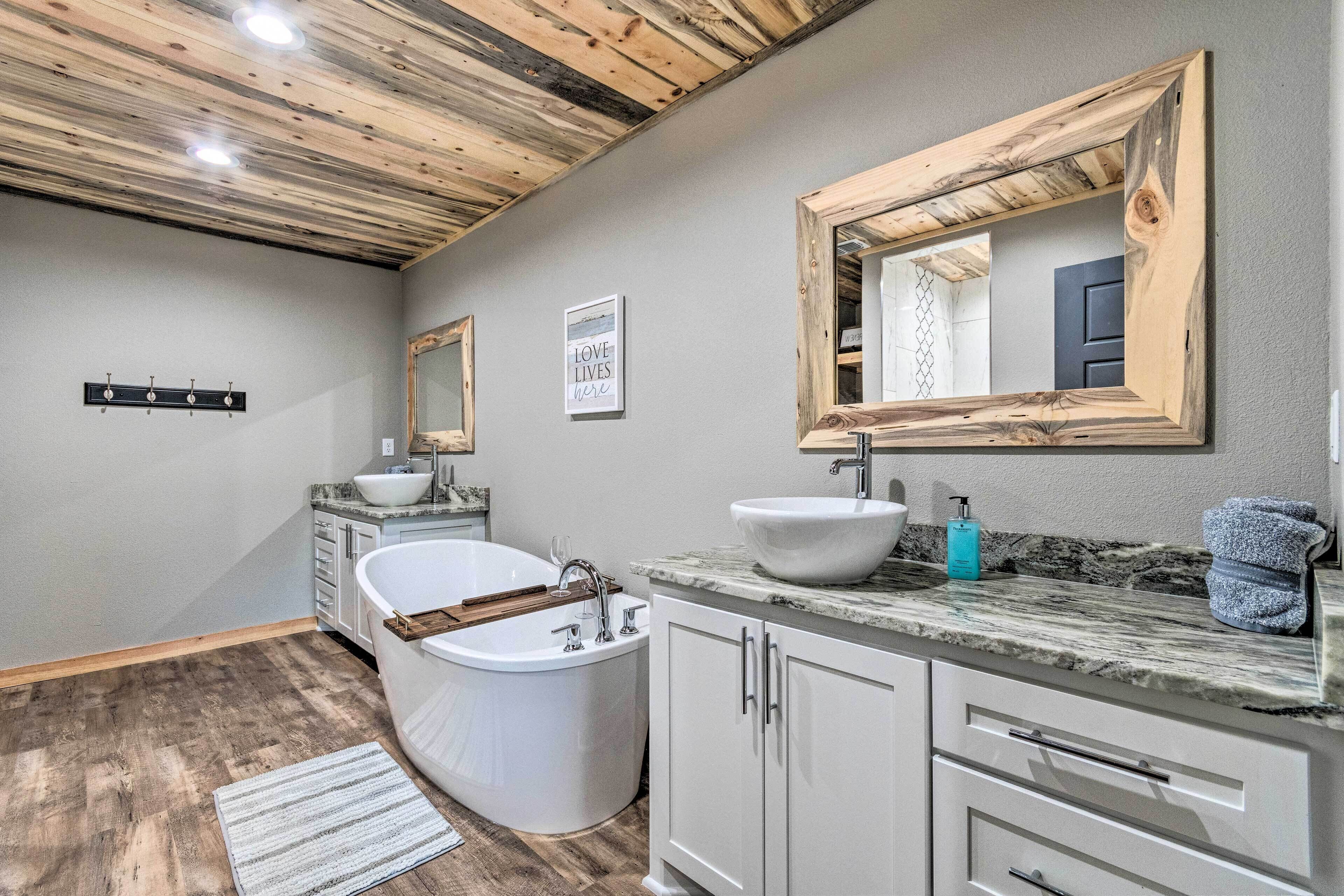 Un bagno moderno con una vasca freestanding, un mobile lavabo e uno specchio grande.