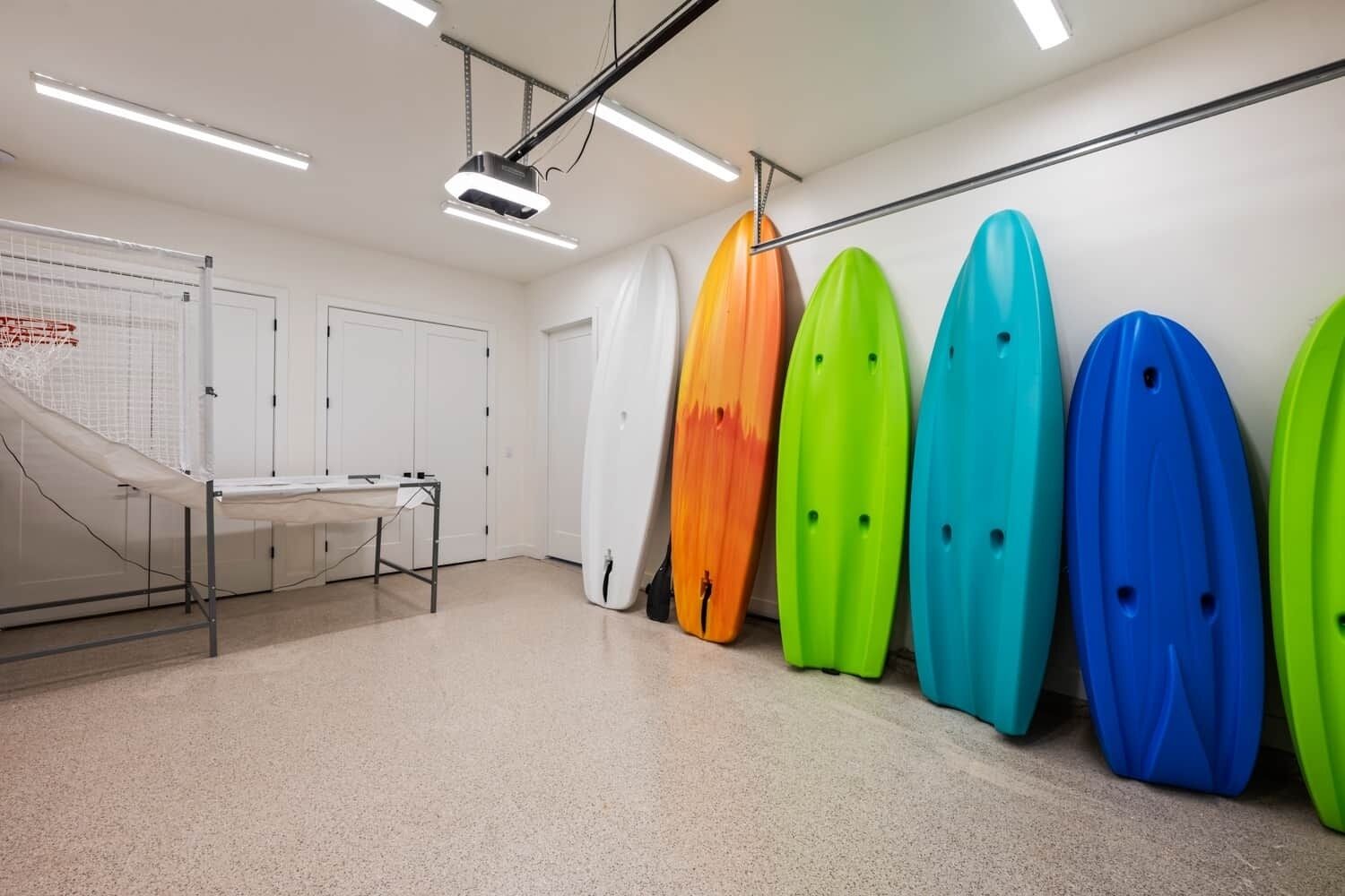 Ein Zimmer mit Surfbrettern an der Wand, einer Tafel und einem Tisch mit Waschbecken.