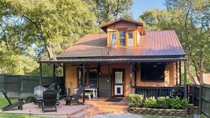 A two-story house with a porch, a grill, and a deck. - Country-chic Cotter Home w/ Outdoor Living Space! (Cotter)