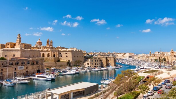 A marina with boats, a historic building with arches, and a clear blue sky. - Bougainvillea Breeze & Marina View (Cospicua)