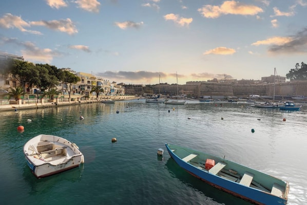 A harbor with boats, a fort, and buildings along the waterfront.