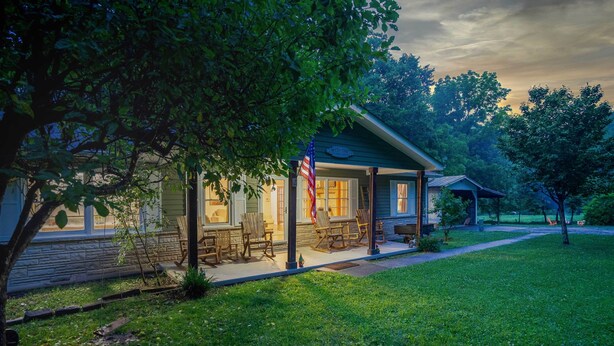 A house with a porch, a flag, and a well-maintained lawn. - Great Smoky Mountains Retreat w/ Fire Pit & Views! (Sevierville)