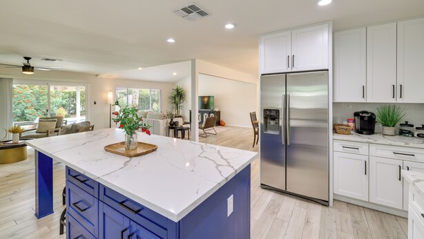 A modern kitchen with white cabinets, a large island, and a stainless steel refrigerator. - 6 Mi to Lookout Mountain: Scottsdale Home w/ Grill (Scottsdale)