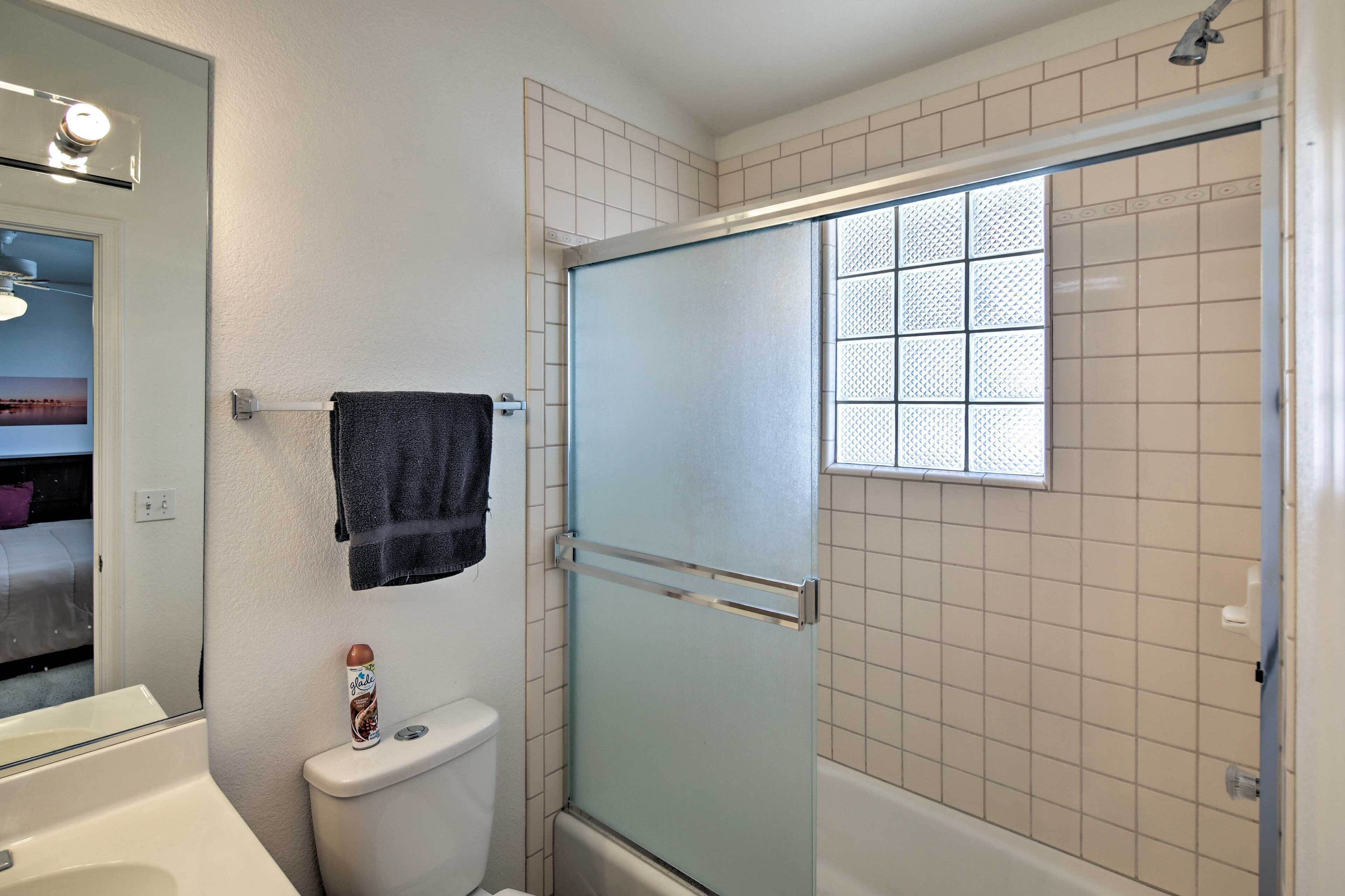 Une salle de bain avec une douche à parois de verre, des toilettes et une baignoire.