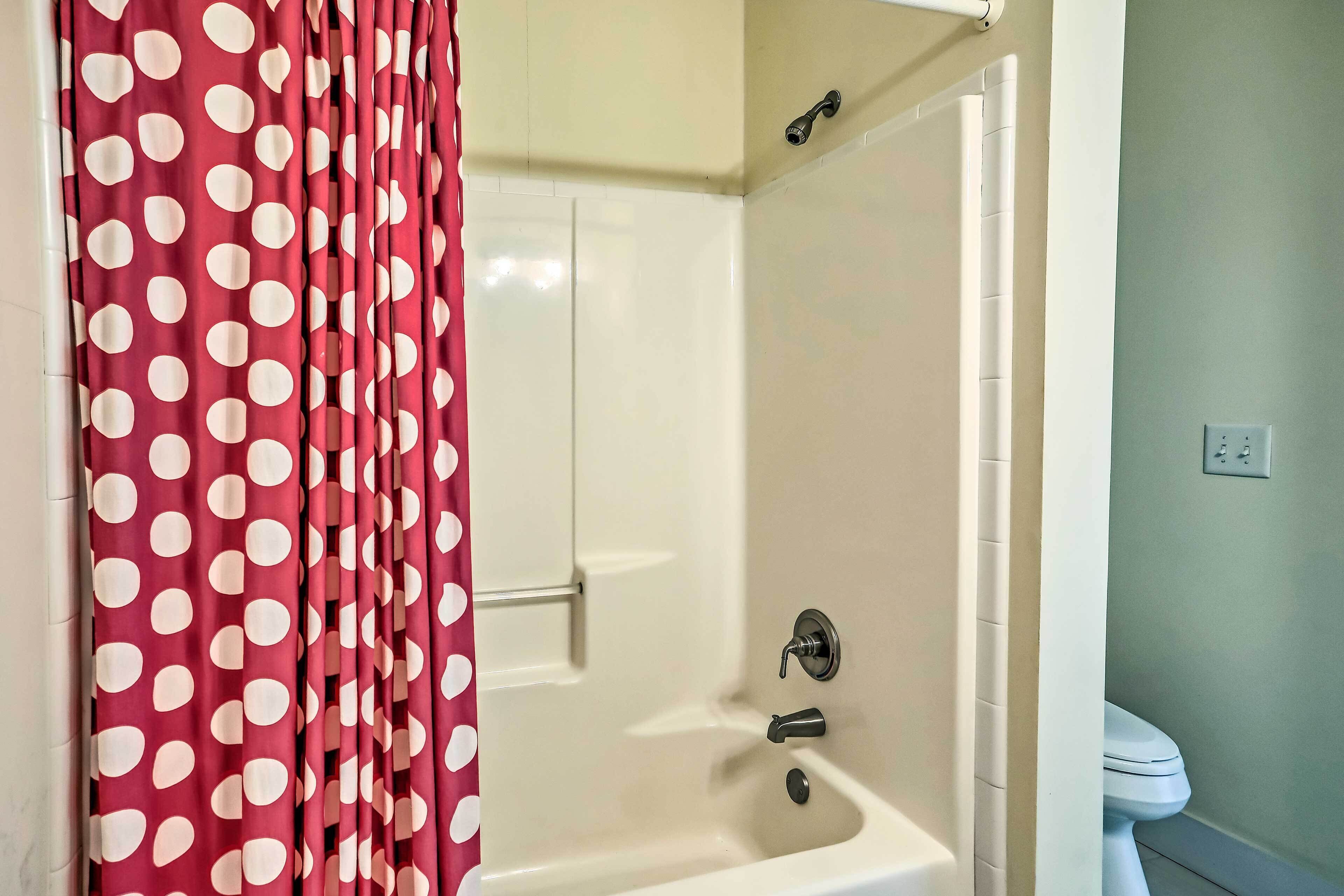 Un baño con bañera, inodoro y zona de ducha.