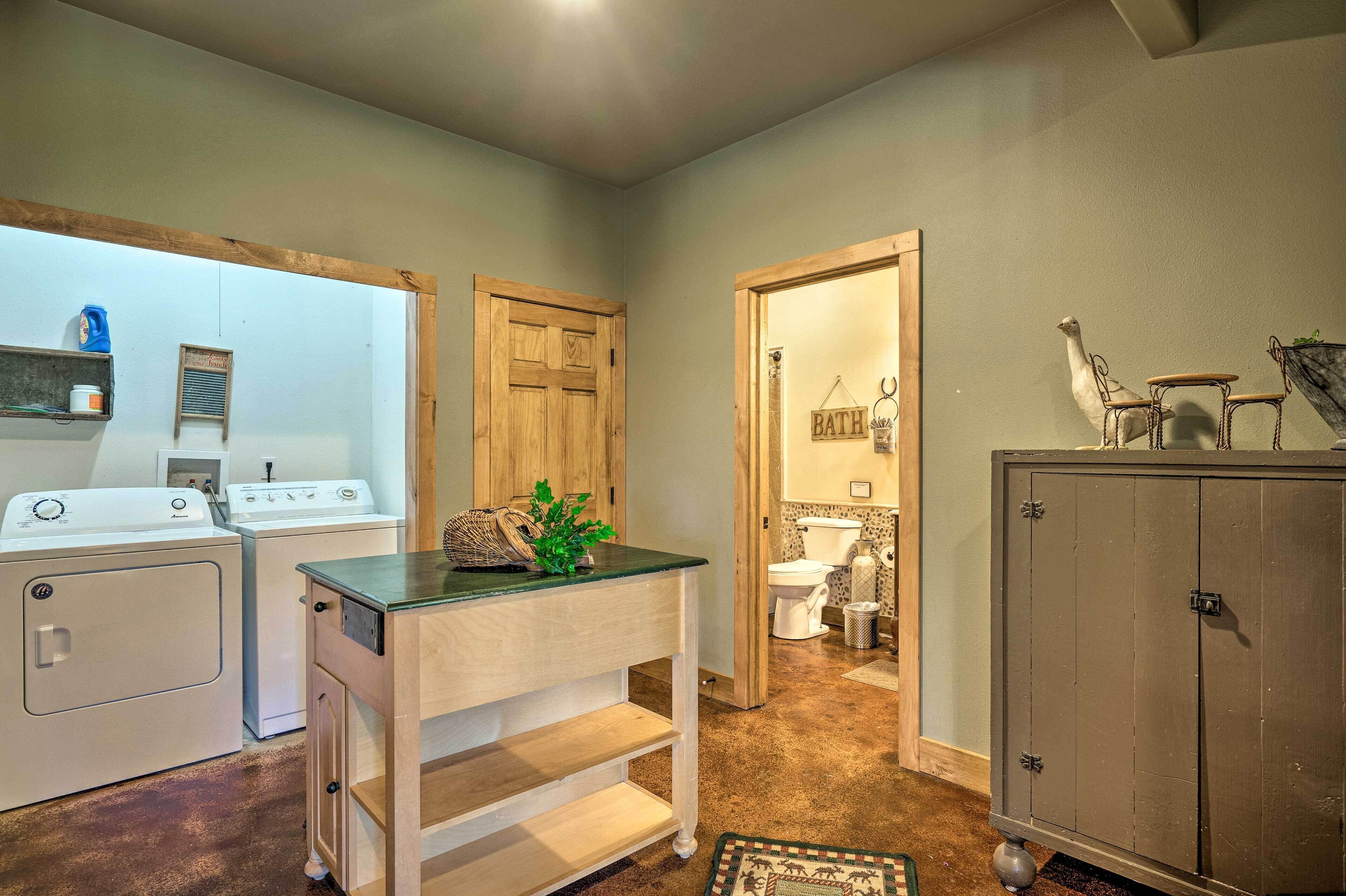 A laundry area with washers and dryers, a wooden cabinet, and a small plant on a counter.
