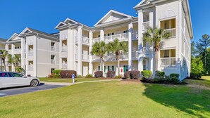 A multi-story hotel with balconies, a parking area, and well-maintained lawns. - Cozy Condo w/ Golf Course View: 4 Mi to Shore! (Myrtle Beach)