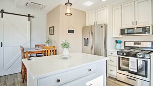 A kitchen with white cabinets, a stainless steel refrigerator, a microwave, and a stove. - Tucson Vacation Rental ~ 5 Mi to Nat'l Park (Tucson)