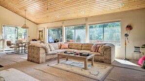 A spacious living room with a large sectional sofa, a coffee table, and a dining area with a table and chairs. - Pine Mountain Club Cottage W/wraparound Deck! (Pine Mountain Club)
