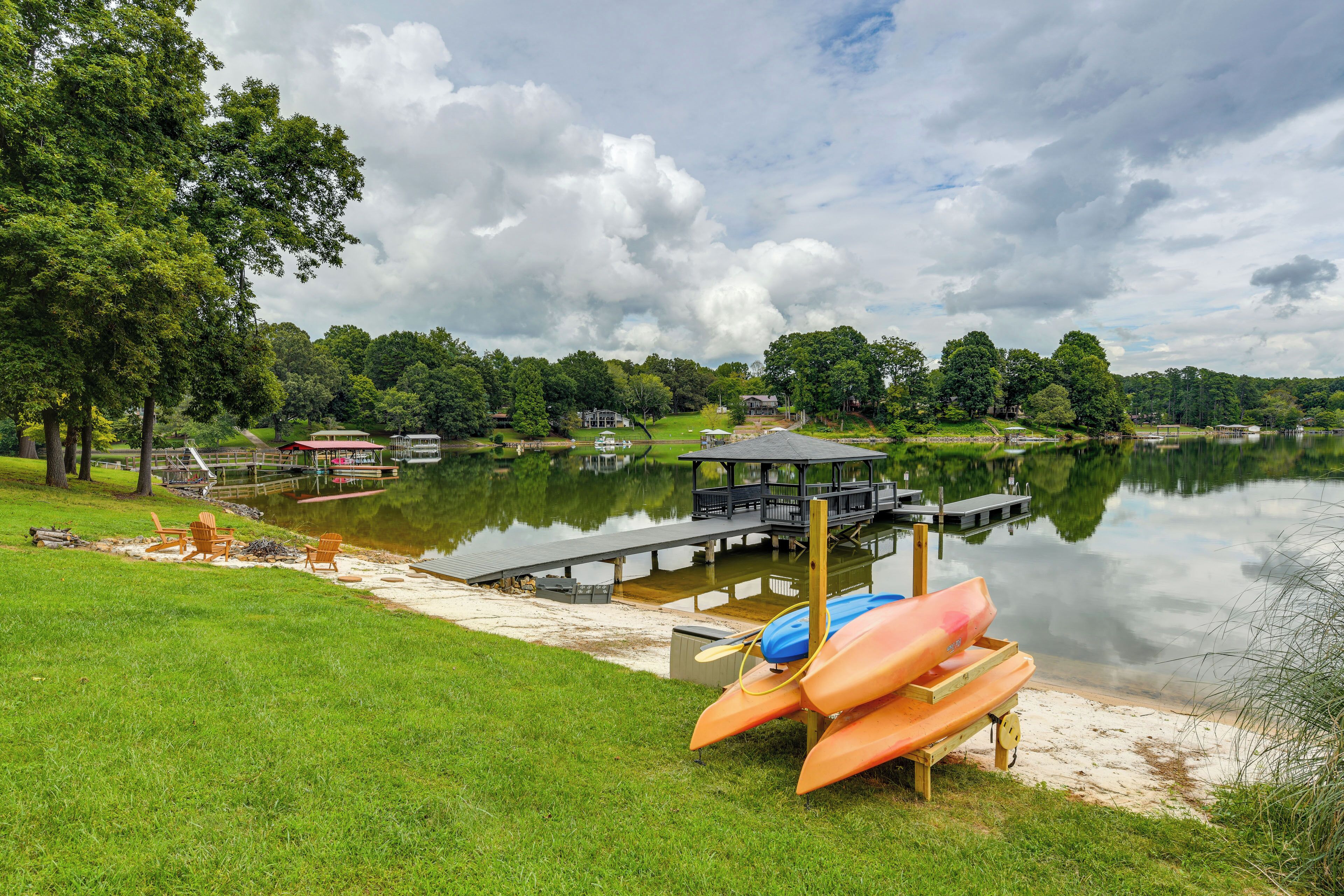 A lakeside dock with canoes, a wooden deck, and a gazebo.