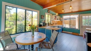 A kitchen with a wooden ceiling, large windows, and a dining area with chairs and a table. - 2 Mi to Riverwalk: Palmetto Gem w/ Fire Pit & BBQ (Palmetto)