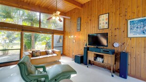 A modern living room with a wooden ceiling, a large TV, and a sofa. - 2 Mi to Riverwalk: Palmetto Gem w/ Fire Pit & BBQ (Palmetto)