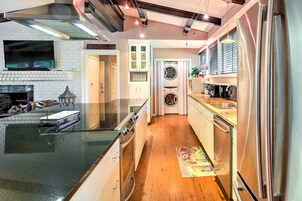 Una cocina moderna con horno integrado, electrodomésticos de acero inoxidable y suelo de madera.