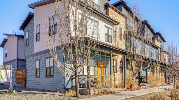 A multi-story residential building with a mix of siding and brickwork, a front porch, and a visible entrance door. - Dtwn Walkability! Grand Junction Couple's Retreat (Grand Junction)