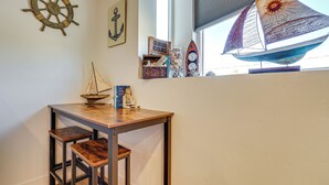 A small table with two wooden chairs, a ship wheel decoration, a framed anchor, and a sailboat model. - Dtwn Walkability! Grand Junction Couple's Retreat (Grand Junction)