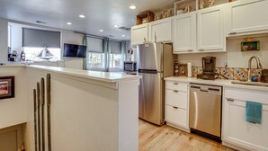 A modern kitchen with white cabinetry, stainless steel appliances, and a wooden island. - Dtwn Walkability! Grand Junction Couple's Retreat (Grand Junction)