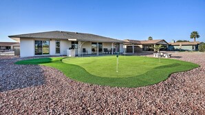 A modern house with a well-maintained lawn and a patio area.