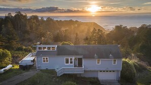 A two-story house with a dock, surrounded by trees and overlooking a body of water. - Hot Tub + Ocean Views: Spacious Irish Beach Home! (Manchester)