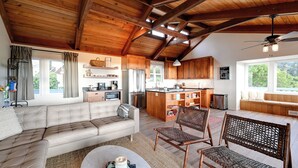 A spacious living area with a sofa, chairs, and a kitchen in the background. - Hot Tub + Ocean Views: Spacious Irish Beach Home! (Manchester)