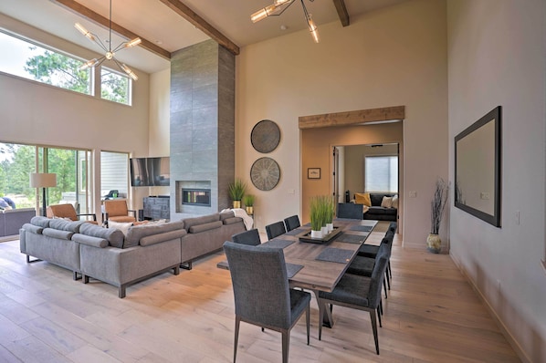 A spacious living area with a large sectional sofa, a dining table with chairs, and a fireplace.