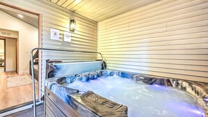 A hot tub with a metal railing, a wooden bench, and a tiled floor. - Spacious Flagstaff Home w/ Hot Tub & Grill! (Flagstaff)