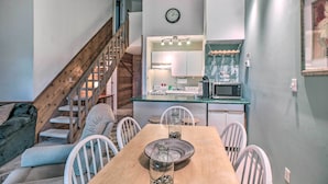 A compact living space with a dining area, kitchen, and staircase. - Slopeside Condo w/ Balcony & Ski Hill Views! (Nellysford)