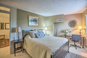 A bedroom with a bed, two bedside tables with lamps, a chair, and a desk with a lamp. - Slopeside Condo w/ Balcony & Ski Hill Views! (Nellysford)