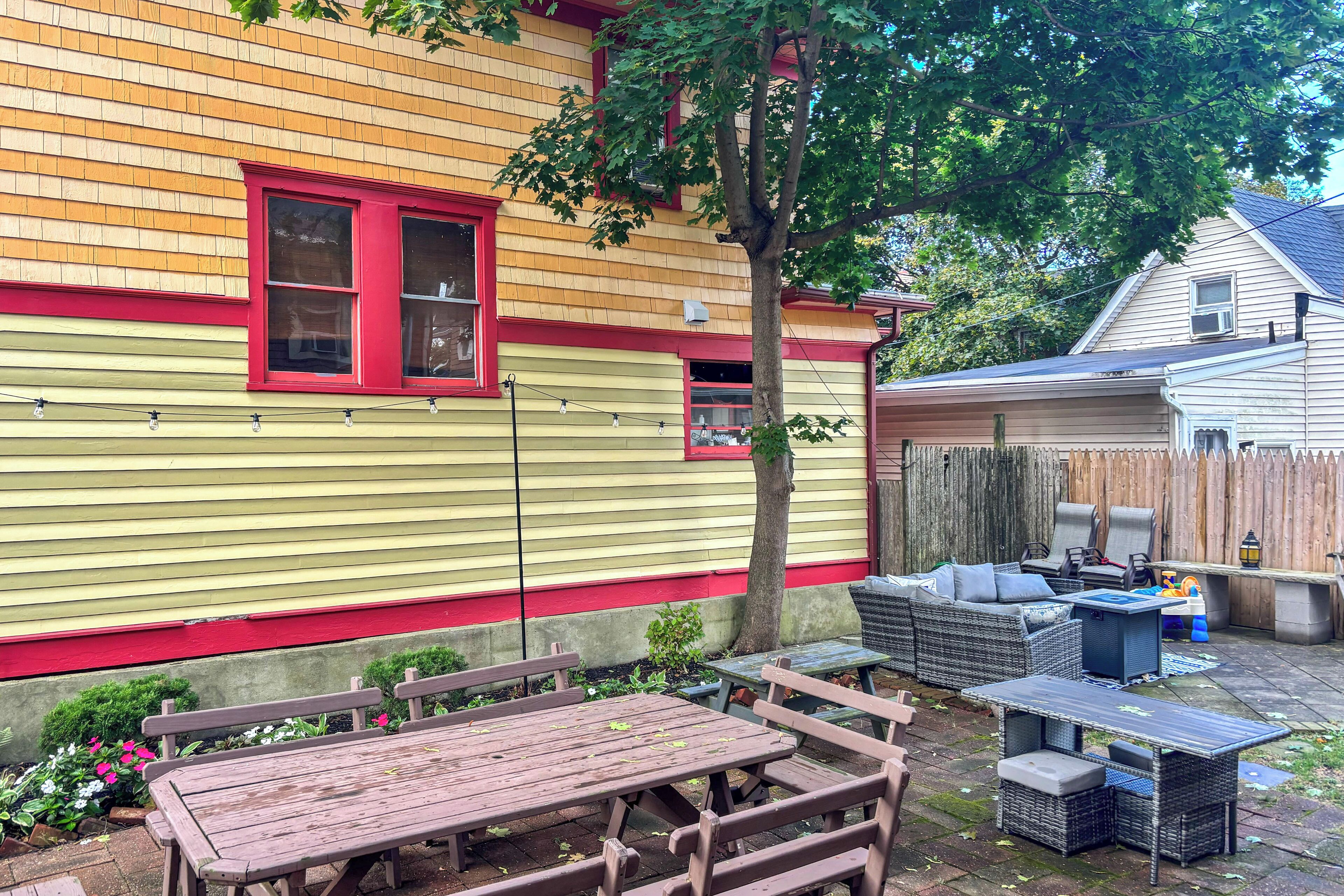 A wooden deck with outdoor furniture, including a table and benches, and a small garden area with flowers.