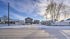 Une rue résidentielle bordée de maisons, une route enneigée et un ciel dégagé.