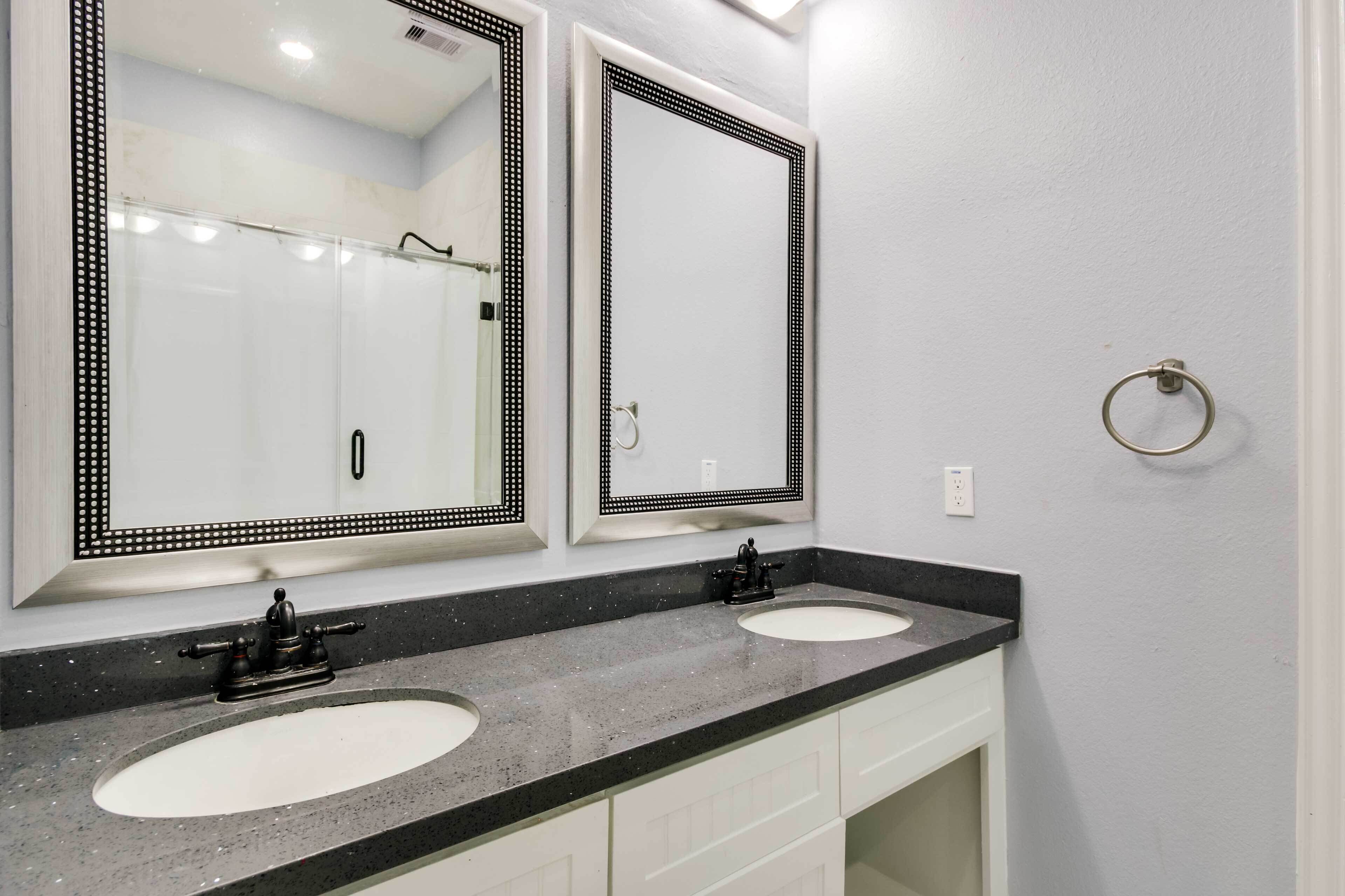 A bathroom with two sinks, a large mirror, and a towel ring.